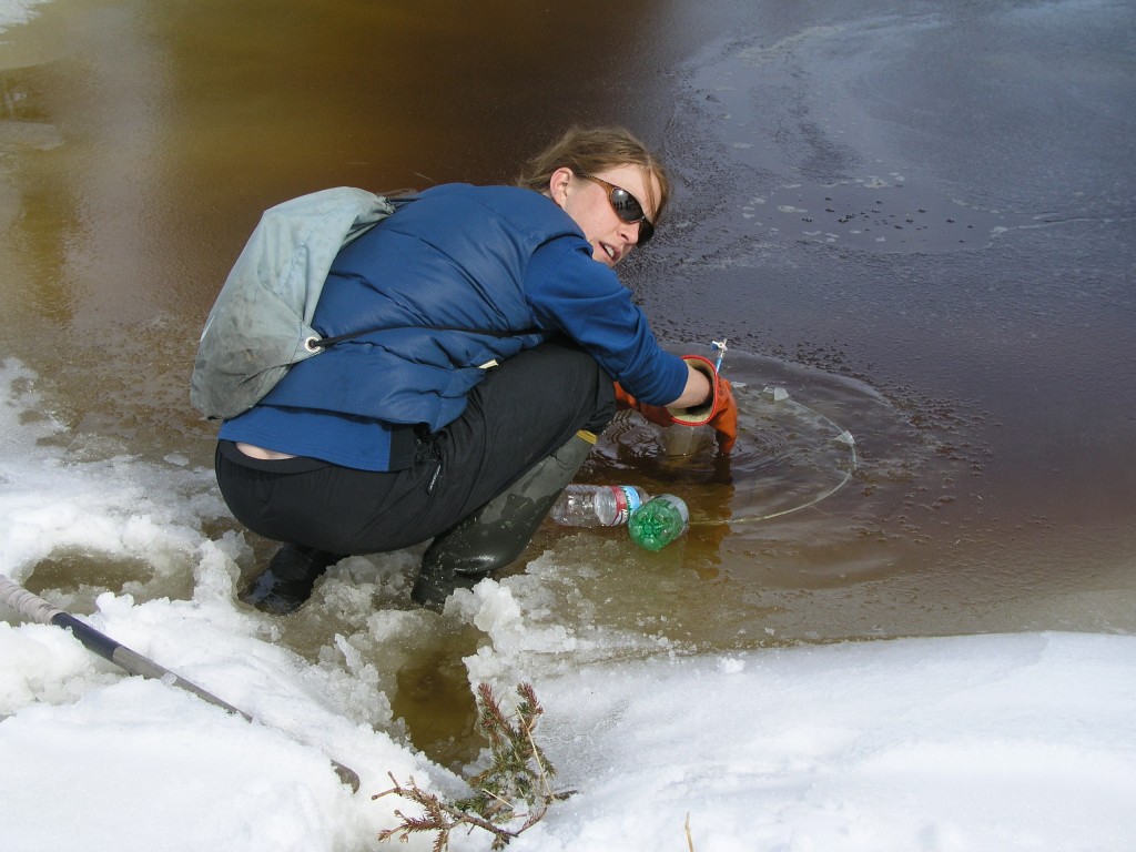 Scientist Laura Brosius collects methane from Eight Mile Lake using an "umbrella trap".