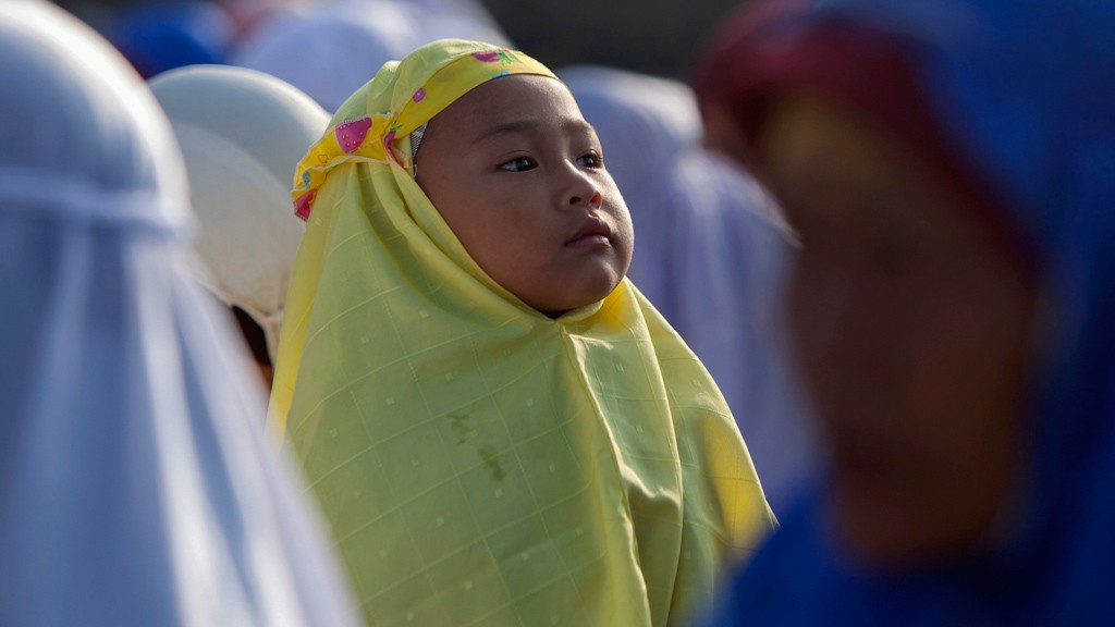  A girl attends a mass prayer during Eid al-Adha festival in Kalitengah village, on the slopes of volcano Mount Merapi, Yogyakarta October 26, 2012. © Reuters